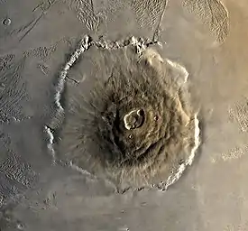 Vue de haut d'une formation montagneuse présentant un large cratère central.