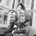 Deux jeunes filles bizutées, coiffées d'un bonnet à grelot, à La Haye (5 septembre 1961). L'une à une tétine à la bouche.