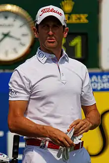 Un golfeur habillé en bas tenant un gant à la main.