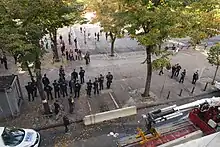  Des opposants à la rénovation de la place Jean-Jaurès de Marseille manifestent pacifiquement devant un groupe de CRS, pendant qu'un muret de béton est installé.