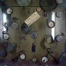 Photographie en couleurs de montres récupérées dans les ruines et exposées au mémorial