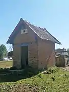 Photographie en couleurs d'une petite maisonnette en brique.