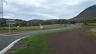 Depuis le chemin de terre parallèle au rond-point, la route départementale 68 se dirige vers Ceyssat.