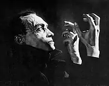 photographie en noir et blanc d'un homme effrayé qui regarde ses mains levées.