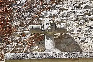 Visage sculpté sur une croix du portail.