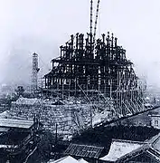 Photographie en noir et blanc de la tour principale en travaux avec de nombreux échafaudages