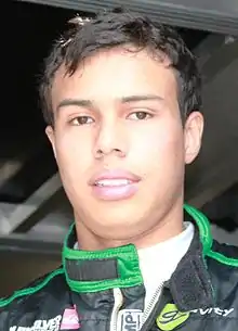 Photographie d'un jeune homme de type sud-américain, brun, en gros plan, de face.