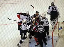 Photo d'arbitres s'interposant entre plusieurs joueurs.