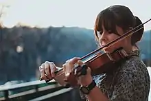 Photographie en couleurs d'une jeune violoniste jouant de son instrument