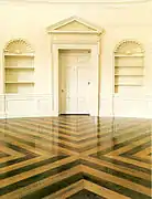Le nouveau plancher du Bureau ovale, refait sous l'administration de George W. Bush. Basée sur le plancher de 1933 conçu par Eric Gugler, la conception de 2005 est faite d'un arrangement contrasté entre des formes radiales de chêne et de noyer. La plupart du plancher est habituellement recouvert d'un tapis elliptique.