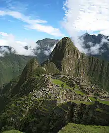 Une vue aérienne d'une cité inca située au milieu d'un paysage de hautes montagnes.
