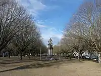 2 rangées d'arbres alignés de part et d'autre d'une large allée, avec au centre le monument aux morts.