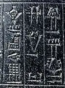 Signes cunéiformes gravés sur une pierre noire.
