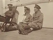 Portrait de trois officiers militaires assis sur le pont d'un navire.