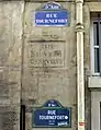 Ancien nom de la rue entre deux plaques récentes ; le mot « STE » a été martelé à la Révolution.