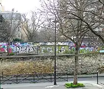 La rue longe l'ancienne ligne de Petite Ceinture décorée de nos jours par de nombreux graffitis.