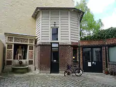 La fontaine se trouve au fond d'une cour pavée.