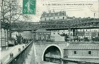 Carte postale en noir et blanc montrant un métro sur une section aérienne en train de franchir un canal