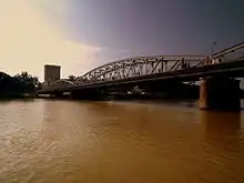 Vue d'un grand pont métallique passant au-dessus d'un fleuve.