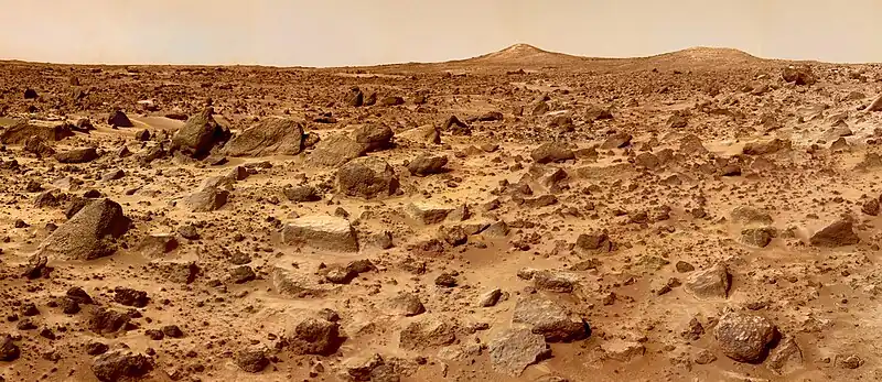Photo panoramique du soite d'atterrissage de Mars Pathfinder. On distingue nettement à l'horizon deux collines baptisées Twin Peaks.