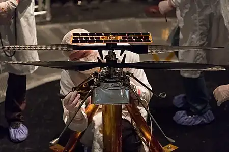 Un technicien sur un modèle aérogire durant la phase de test dans une chambre à vide au JPL, dans le cadre du projet de vol du mini-hélicoptère Ingenuity (a volé sur mars le 19 avril 21).