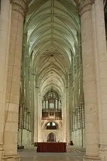 Intérieur d'une vaste église dont la voûte, située à une trentaine de mètres de hauteur, est soutenue par d'étroits piliers. Certains de ces derniers connaissent un fort déversement. Au fond, installé sur une tribune, un orgue dans un buffet de bois de style baroque.