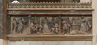 Bas-relief représentant, de gauche à droite, un ange aux côtés de saint Quentin, saint Quentin prêchant devant une dizaine de personnes, saint Quentin à côté de deux hommes plongés dans une bassine d'eau.