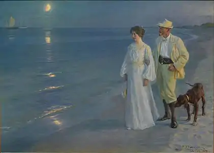 Un couple marchant sur la plage avec un chien, un quart de lune en arrière-plan.