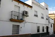 Photographie d'une maison blanche, vue depuis la rue