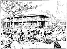 Gravure détaillée du palais royal d'Uvea en 1900. On y voit de nombreuses personnes assis tout autour.