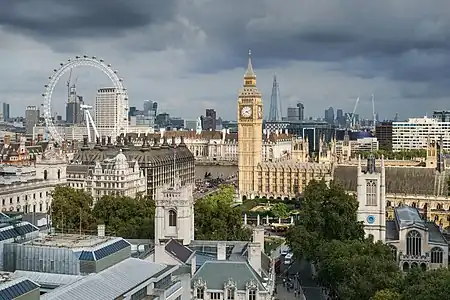 Vue du Parlement britannique et de Big Ben au premier plan à droite, la London Eye au premier plan à gauche et le Shard avec le quartier de Canary Wharf au dernier plan en septembre 2014.