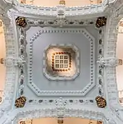 Un carré blanc richement décoré découpé dans des arcades.