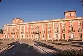 photo : façade d'un palais de brique rouge comportant trois niveaux et 14 fenêtres par étage.