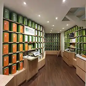 Une grande pièce aux murs couverts d'étagères, sur lesquelles on trouve des grands pots en métal vert.