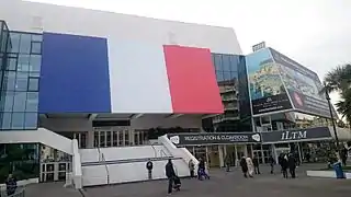 Le Palais des festivals et des congrès de Cannes, arbore un drapeau français sur sa façade.