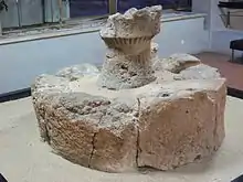 Un bloc de pierre avec une tour de pierre au-dessus, en mauvais état.