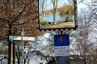 Panneau routier dédié à un itinéraire cyclable européen situé le long d'un cours d'eau.