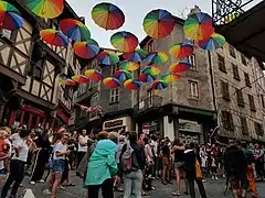 Photographie de la place du Pirou avec son château à colombages lors d'une manifestation.