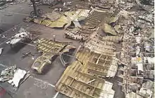 Photo montrant, en plongée, un alignement de débris divers posés sur le sol d'un hangar.