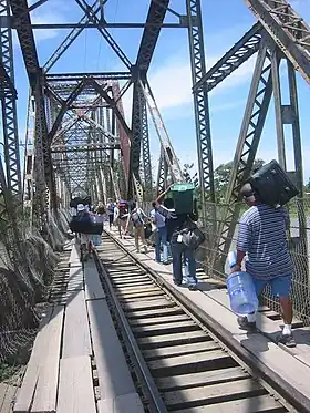 Passage de la frontière sur un pont ferroviaire désaffecté franchissant le Rio Sixaola entre les villes de Sixaola (Costa Rica) et Guabito (Panamá).