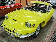 Photo d'un coupé sportif jaune exposée dans un musée.