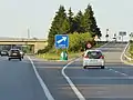 Musoir de sortie d'autoroute, ici en vert avec deux flèches.