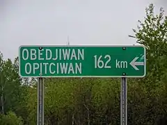 Signalisation routière bilingue français-atikamekw en route vers le village.