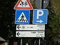 Panneaux routiers trilingues (italien-français-allemand).