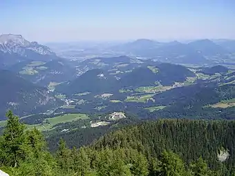 Panorama vers le nord, depuis la route qui mène au Nid d’aigle. Salzbourg est à peine visible au fond. Berchtesgaden se trouve juste sur la gauche en dehors du cadre. Le Kempinski Hotel (de) est au centre, au pied de la montagne.