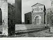 Photographie en noir et blanc de la façade d'une église romane entouré de hauts bâtiments en pierre.