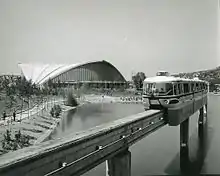 Un tramway passant devant la Palavela sur une photo en noir et blanc.