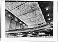 1932 image of auditorium ceiling and balcony soffit. Round holes in balcony edge are for stage lighting instruments. Dark windows in far wall are for film projectors and spotlights.[Traduire passage]