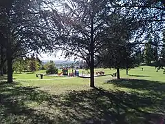 L'aire de jeux du parc Saint-Hubert, avec en fond une vue sur la vallée de la Bourbre.