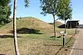 Vue rapprochée de tumulus en terre engazonnés.